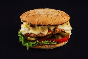 hamburguesa con queso con queso salsa y en escabeche pepinos en un negro foto