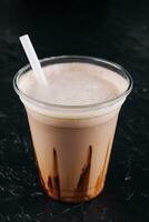 milkshake in a plastic cup on black background photo