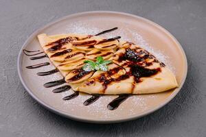 Crepes with fresh banana slaces and dark chocolate photo