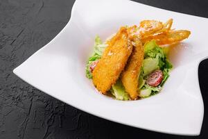 Chicken nuggets with vegetables salad on plate photo