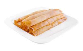 Tasty thin pancake rolls on white plate photo