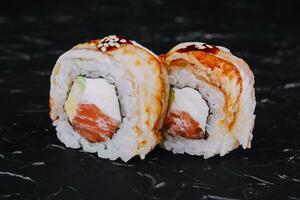 canada roll with salmon on black stone photo