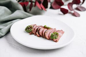 Sliced duck breast roasted meat on a plate photo