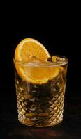 Old-fashioned cocktail with ice and orange slice photo