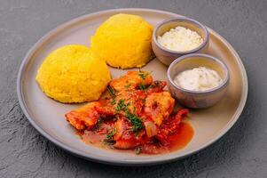 Traditional Moldavian, Romanian cornmeal porridge with meat and sauce photo