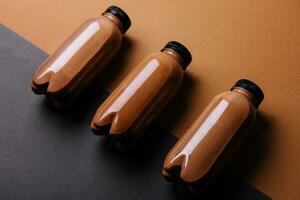 chocolate smoothies milkshake in bottles on brown background photo