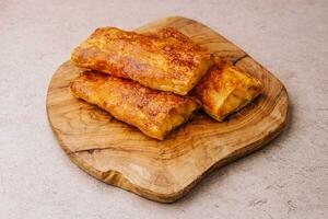 Baking puff pastry with potatoes on wood board photo