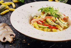 Bolognese pasta with mushrooms, cucumbers and peppers in sauce photo