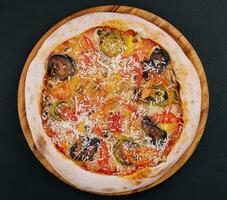 vegan pizza with roasted vegetables on wooden board photo