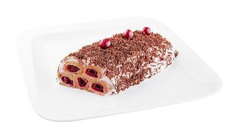 Cake from rolled pancakes with cream, cherries and grated chocolate on plate photo