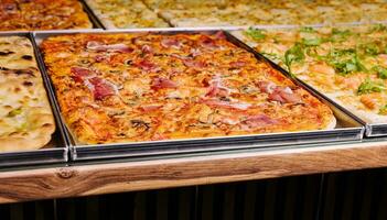 Tasty square pizzas on metal trays photo