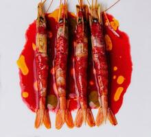 Grilled tiger prawns on a ceramic plate, top view photo