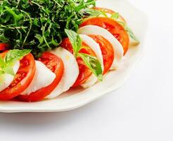 Traditional italian caprice salad tomato mozzarella cheese and basil photo