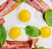 Fried eggs and bacon for breakfast on top view photo