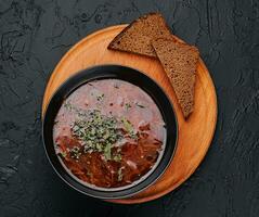 Traditional Ukrainian red soup borsch with slices of bread photo