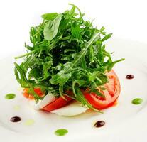 Green salad with arugula, tomato and feta cheese photo