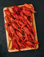 Fragrant boiled crayfish on a wooden board photo