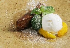 Chocolate brownie with ice cream and vanilla powder photo