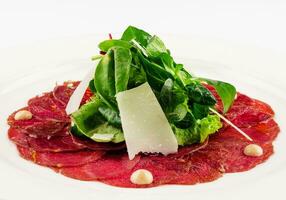 Beef carpaccio with parmesan cheese close up photo