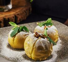 Baked apples stuffed with walnuts on plate photo