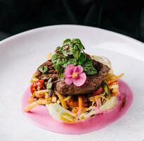 Beef medallions with fresh salad on plate photo