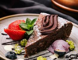 Brownie cake with a scoop of vanilla ice cream and strawberries photo