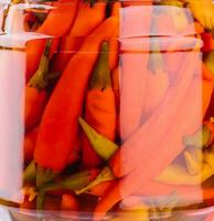 Glass jars with pickled chili peppers background photo