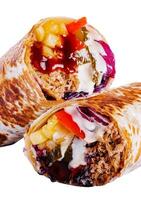 fresh roll of thin lavash or pita bread filled with grilled meat photo