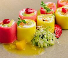 Sweet sushi with pineaplle, strawberries with pomegranate photo