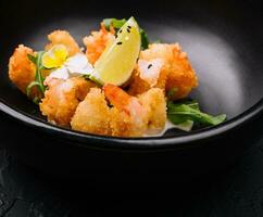 fried crispy shrimp on black plate photo