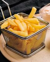 French fries in metal wire basket isolated photo