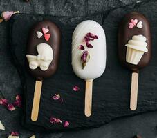 Top view of decorated cake pops ice creams on black background photo