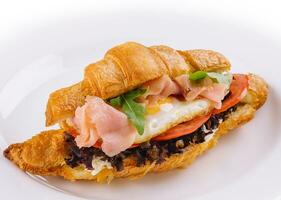 breakfast with croissant sandwiches with fried egg and salmon photo