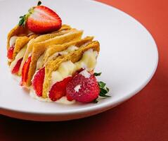 Strawberries and cream mille feuille dessert on plate photo
