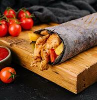 black lavash with chicken on black board photo