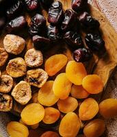 Different dried fruits on wooden background photo