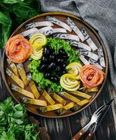 un composición con ahumado arenque piezas con vegetales en plato foto