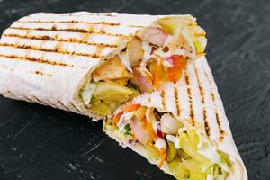 Delicious chicken shawarma on black stone photo