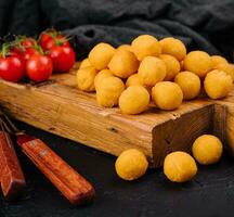 sabroso queso pelotas en un de madera tablero foto