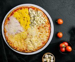 different types of cheese on a big pizza photo