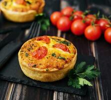 Cheddar cheese and spring onion omelette tarts served on wooden board photo