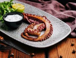 Traditional french octopus braised cooked with salicornia, lemon curd and spice photo