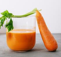 Carrot juice and fresh carrot closeup photo