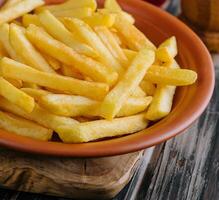 Fresh tasty french fries on a wooden cutting board photo