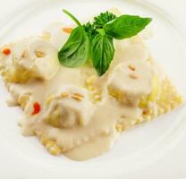 Plate of tasty traditional italian ravioli with basil photo