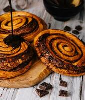 sweet chocolate cinnamon rolls on wood photo