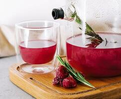 fruit raspberry tea in glass teapot and cup photo