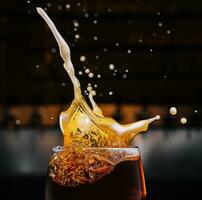 closeup splashes glass of dark Belgian beer photo