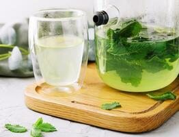 green tea in a jug and a cup with mint photo