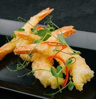 Fried shrimps tempura on black stone plate photo